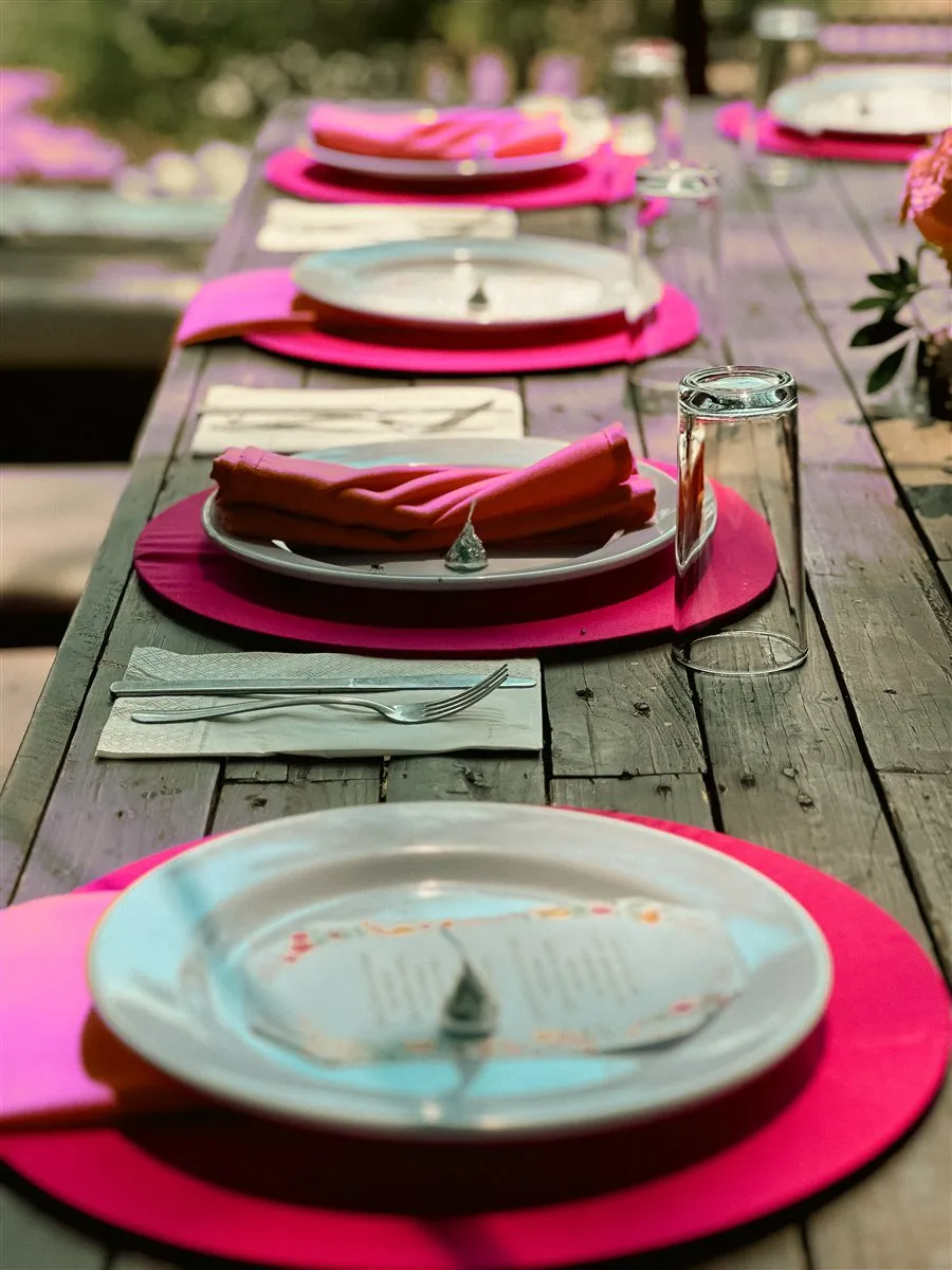 Mesa decorada con vajilla y detalles en tonos fucsia