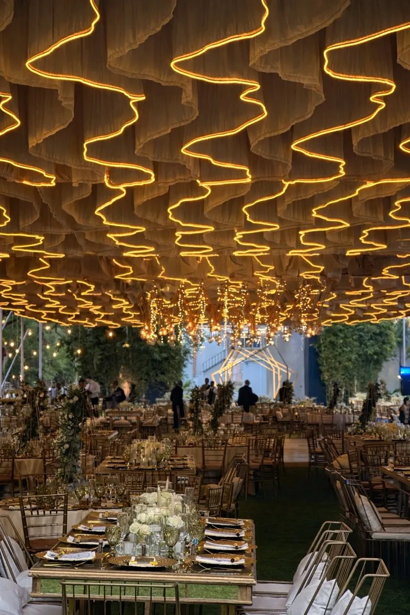 Banquete de boda montado bajo carpa con luces cálidas