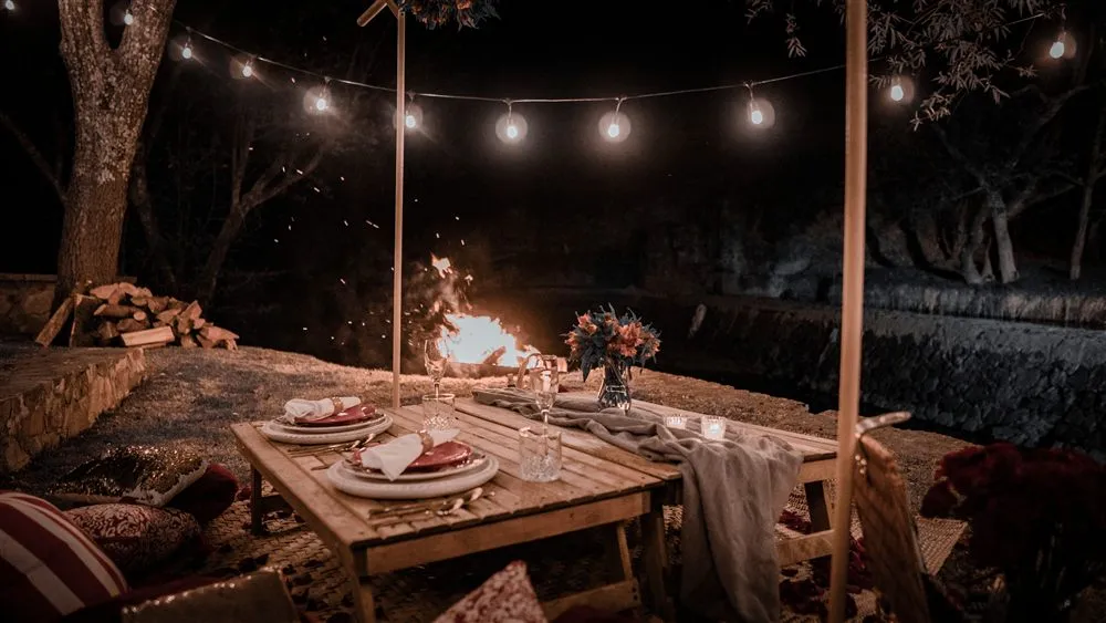 Cena nocturna iluminada con luces colgantes