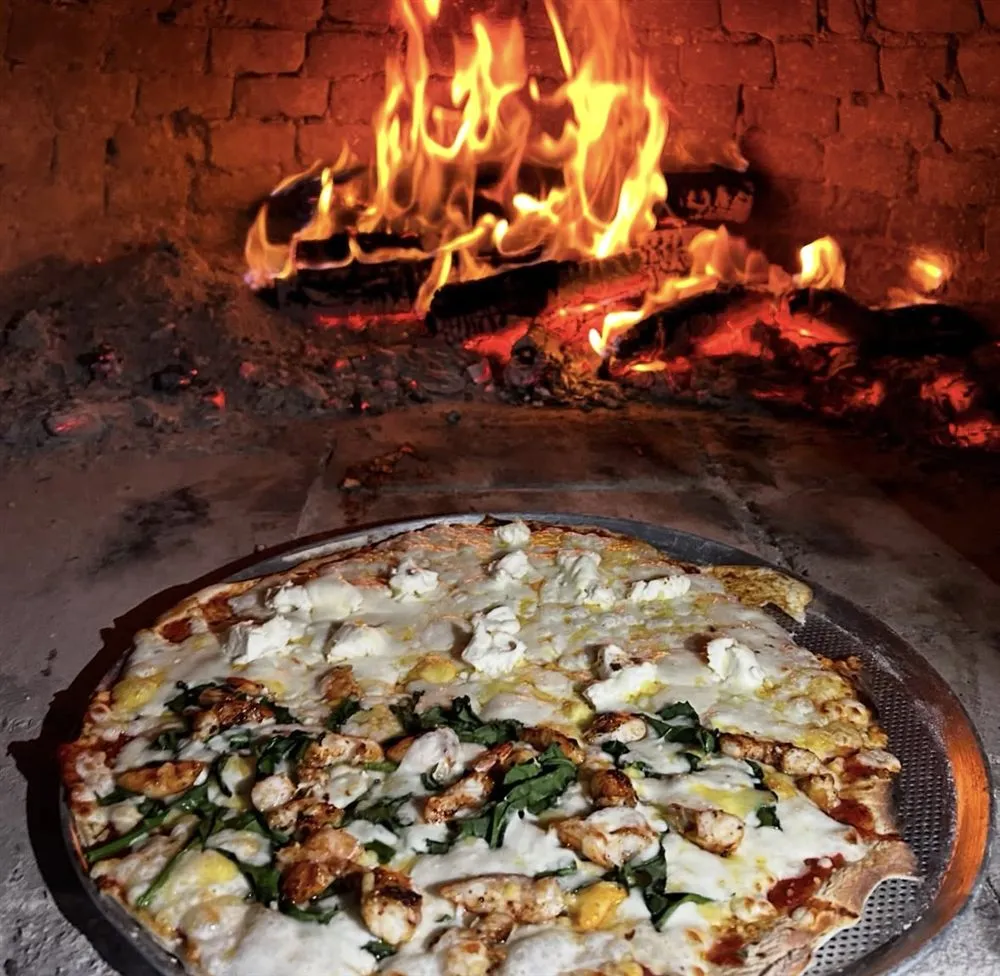 Pizza artesanal recién salida del horno de leña