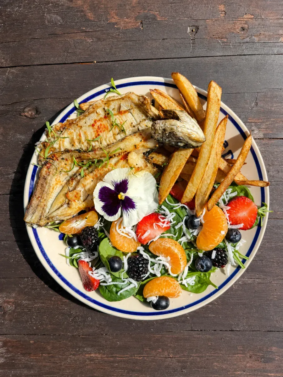 Plato de trucha a la parrilla con guarniciones en Las Cascadas